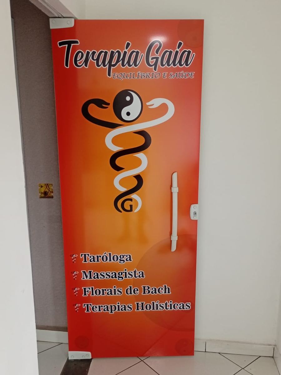 Porta de vidro da Terapia Gaia totalmente adesivada em laranja, com o logotipo, o símbolo e a lista de terapias